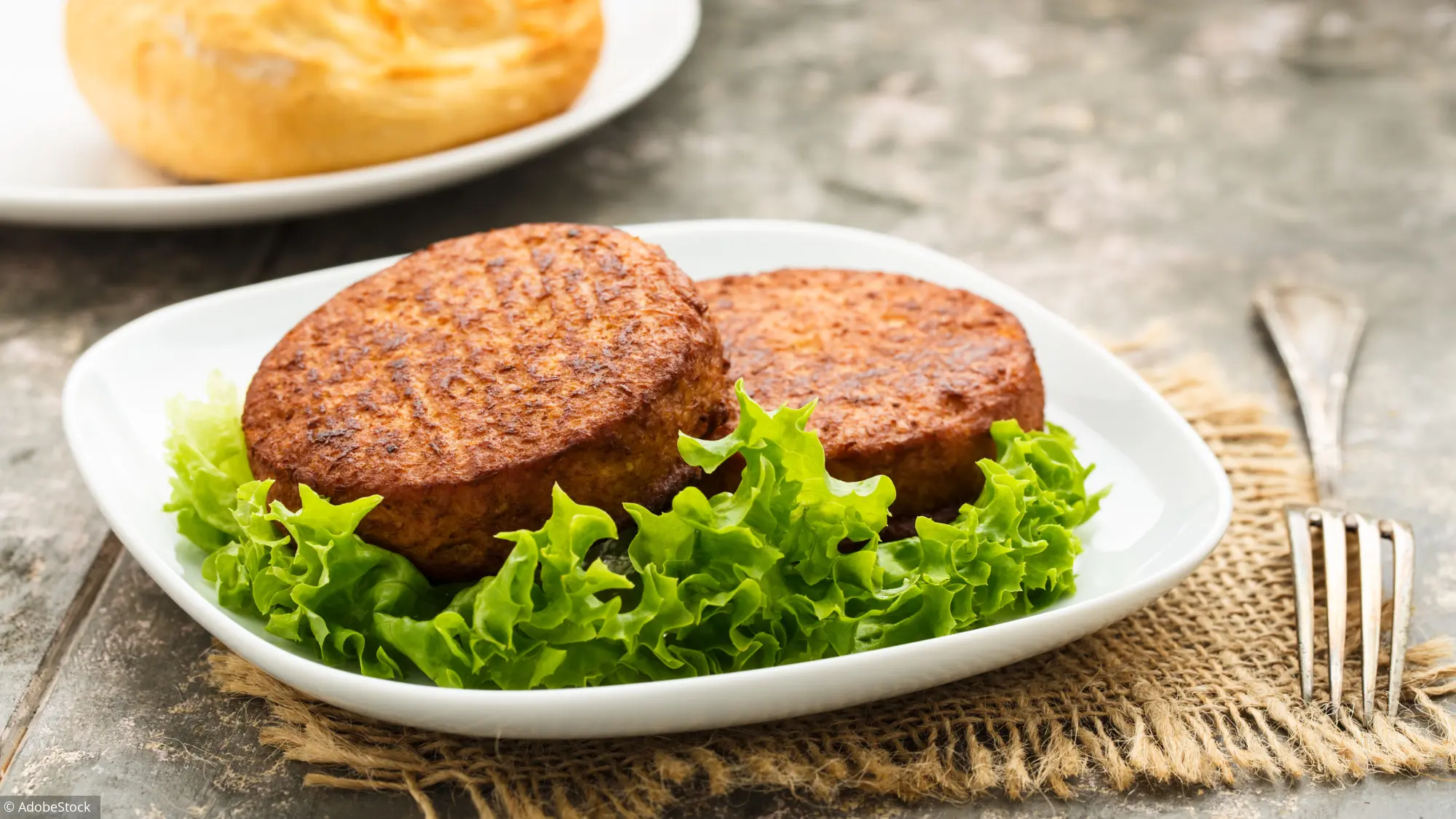 steaks végétals sur lit de laitue avec sauce en arrière-plan