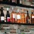 Assorted wine bottles on rustic stone shelves in a cozy setting.