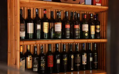 A stylish arrangement of wine bottles showcased on wooden shelves in a bar setting.