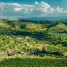 Aerial view of lush vineyards and rolling hills under a dramatic sky.