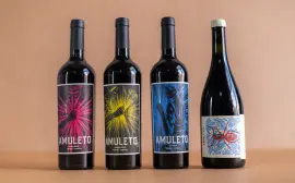 Four exquisite wine bottles with vibrant artistic labels on a minimalist background, perfect for a winery product showcase.