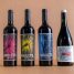 Four exquisite wine bottles with vibrant artistic labels on a minimalist background, perfect for a winery product showcase.