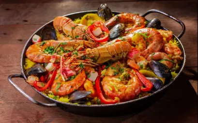 A vibrant and flavorful seafood paella served in a pan with mussels and shrimp.