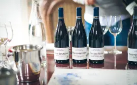 Elegant wine tasting setup in Beaune, featuring French wine bottles and glasses on a table.