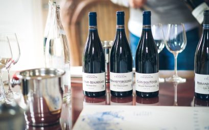 Elegant wine tasting setup in Beaune, featuring French wine bottles and glasses on a table.