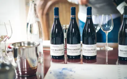 Elegant wine tasting setup in Beaune, featuring French wine bottles and glasses on a table.