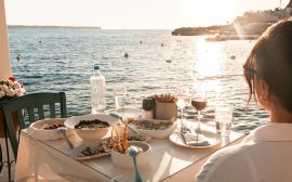 Seaside dinner in fira, greece during golden hour