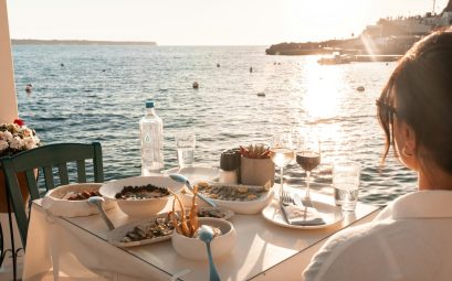 Seaside dinner in fira, greece during golden hour