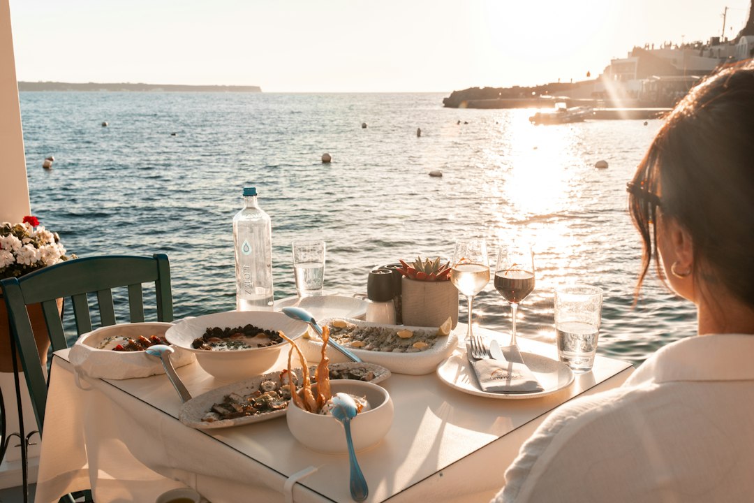 Seaside dinner in fira, greece during golden hour