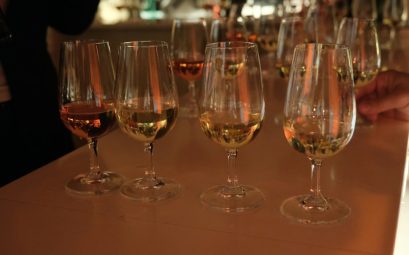 Several glasses of amber liquid on a bar
