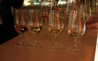 Several glasses of amber liquid on a bar