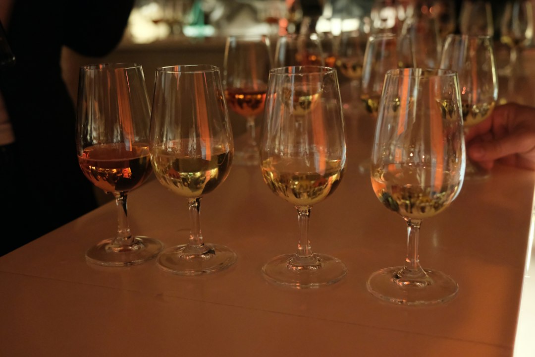 Several glasses of amber liquid on a bar
